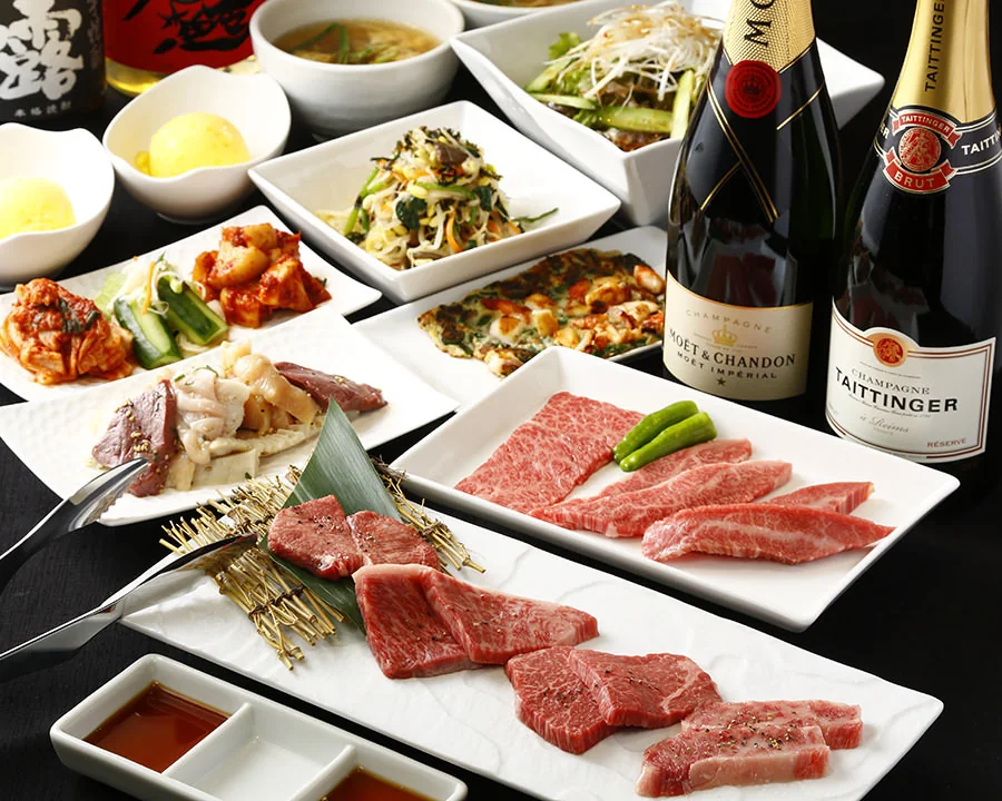 和牛と前菜、シャンパンを並べたコース料理