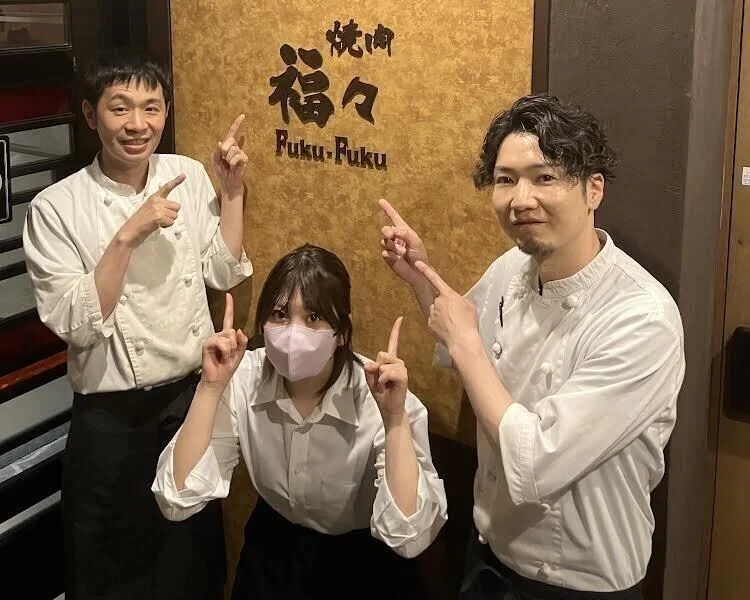 福々の看板の前で笑顔のスタッフ